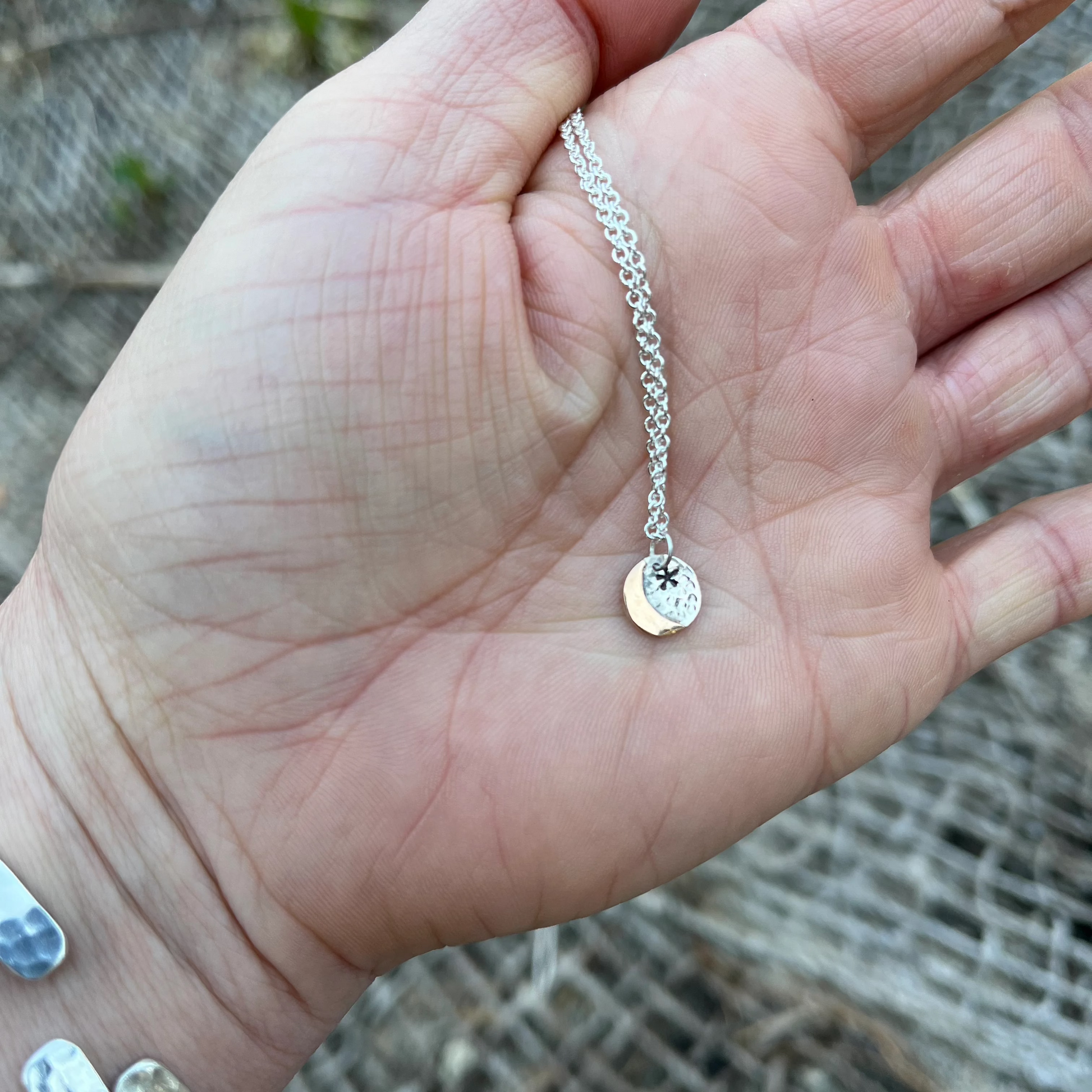 Tiny gold moon on silver back