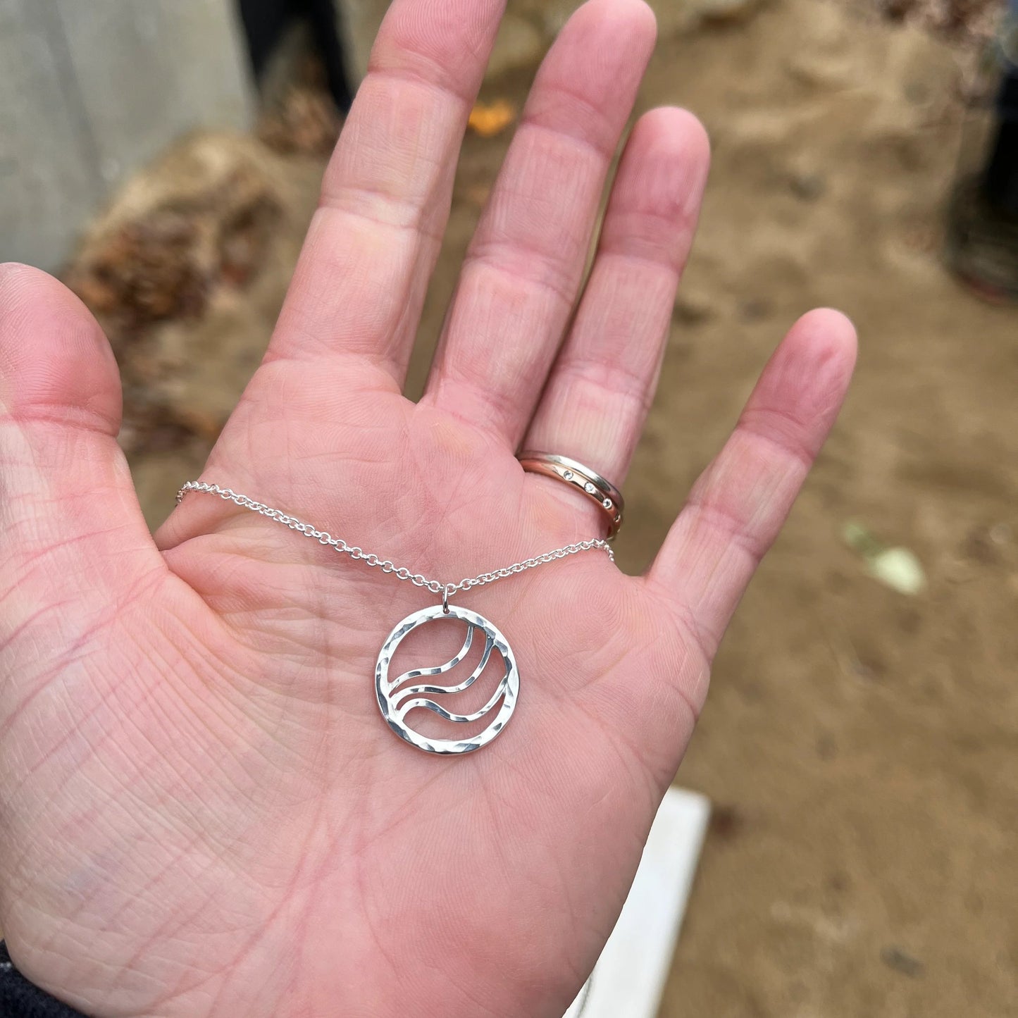 Round silver pendant with ripple waves