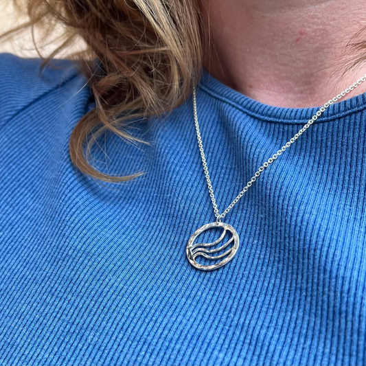Round silver pendant with ripple waves